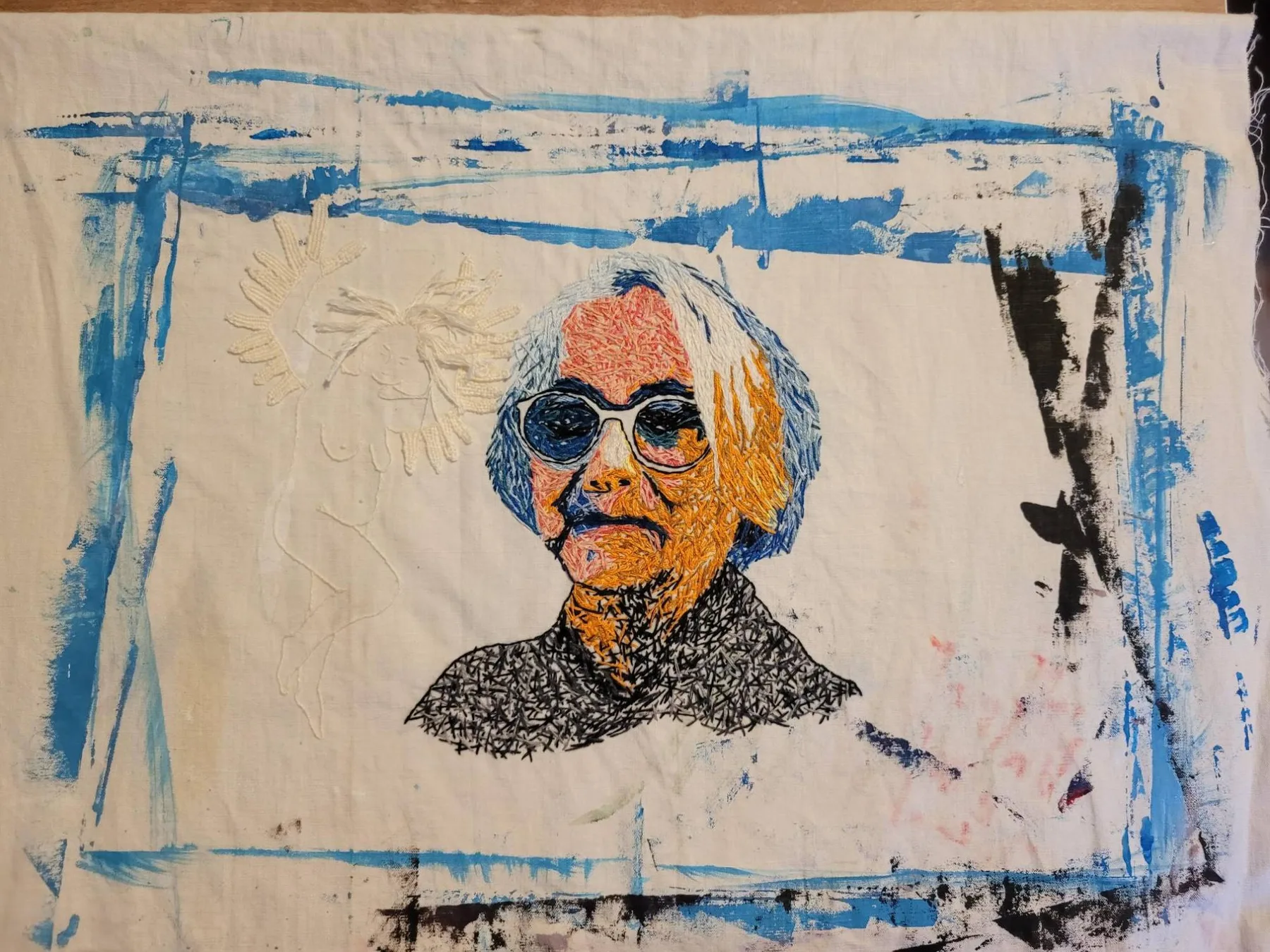 Embroidered and painted textile portrait, an example of Red Thread's textile art practice
